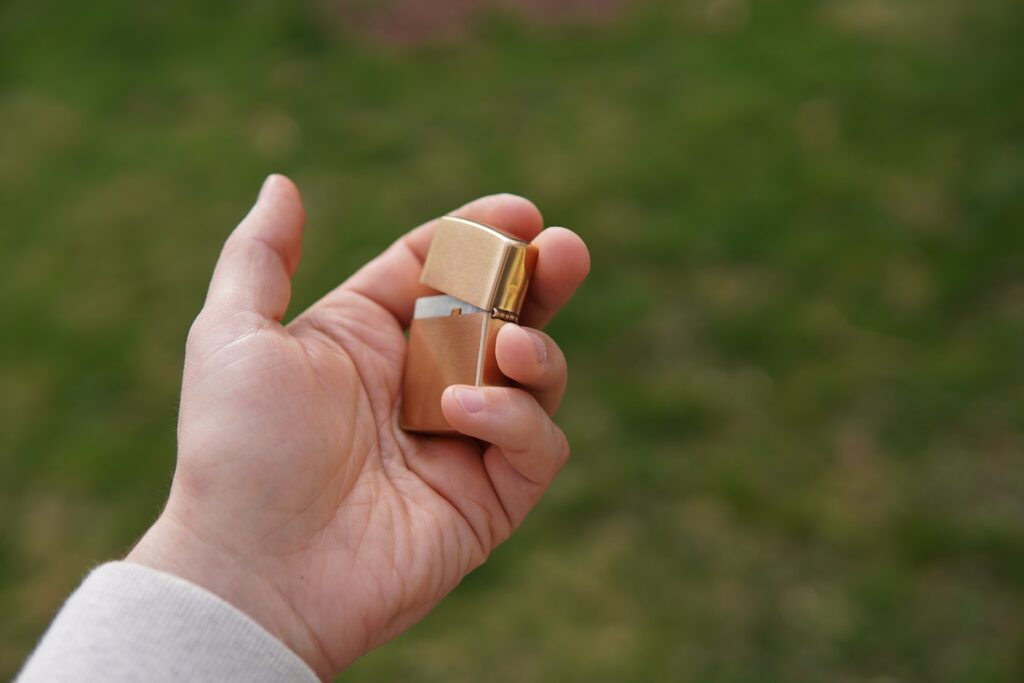 ZippoNode Meshtastic device held in a hand — pocket-sized